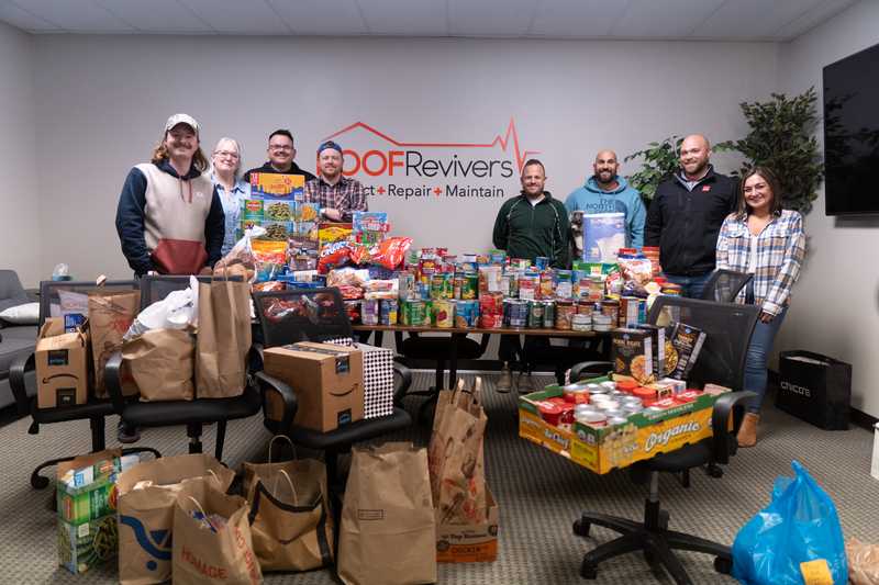 Roof Revivers team standing in front of a portion of the donations for their 2025 Food Drive benefitting GRIN of Gahanna, Ohio.
